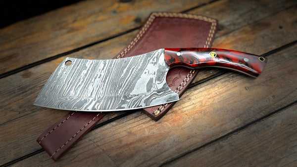 A BigHorn Steel Damascus cleaver with a blended red and black handle and leather sheath